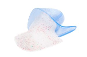 Spilled powder from blue cup in white background